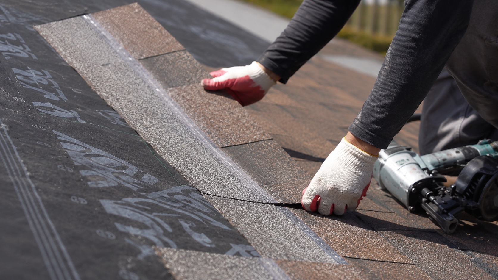Roofer installing architectural shingles on a residential roof